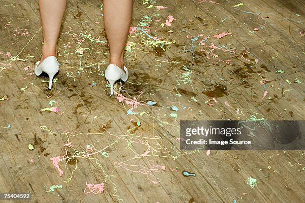 woman standing on a messy floor - party string stock pictures, royalty-free photos & images