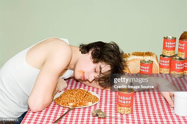 teenage boy sleeping near a plate of beans - baked beans stock pictures, royalty-free photos & images