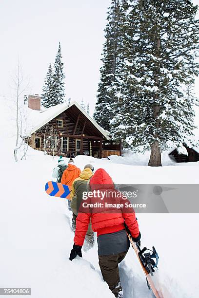 snowboarders returning to chalet - winter cabin stock pictures, royalty-free photos & images