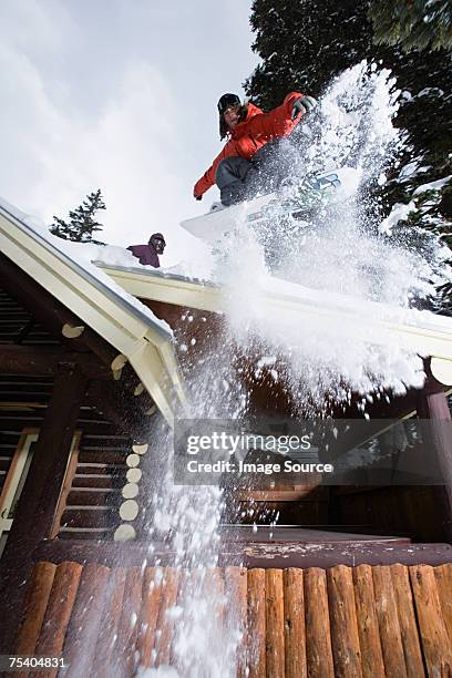 man snowboarding off chalet roof - snowboard jump bildbanksfoton och bilder
