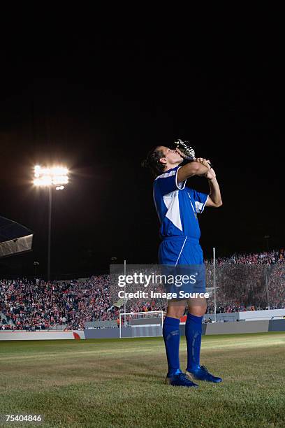 footballer kissing trophy - trophy stand stock pictures, royalty-free photos & images