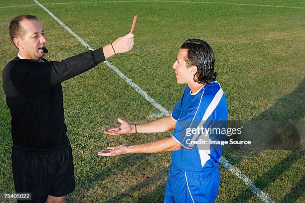 schiedsrichter die rote karte zeigen fußballer - schiedsrichter stock-fotos und bilder