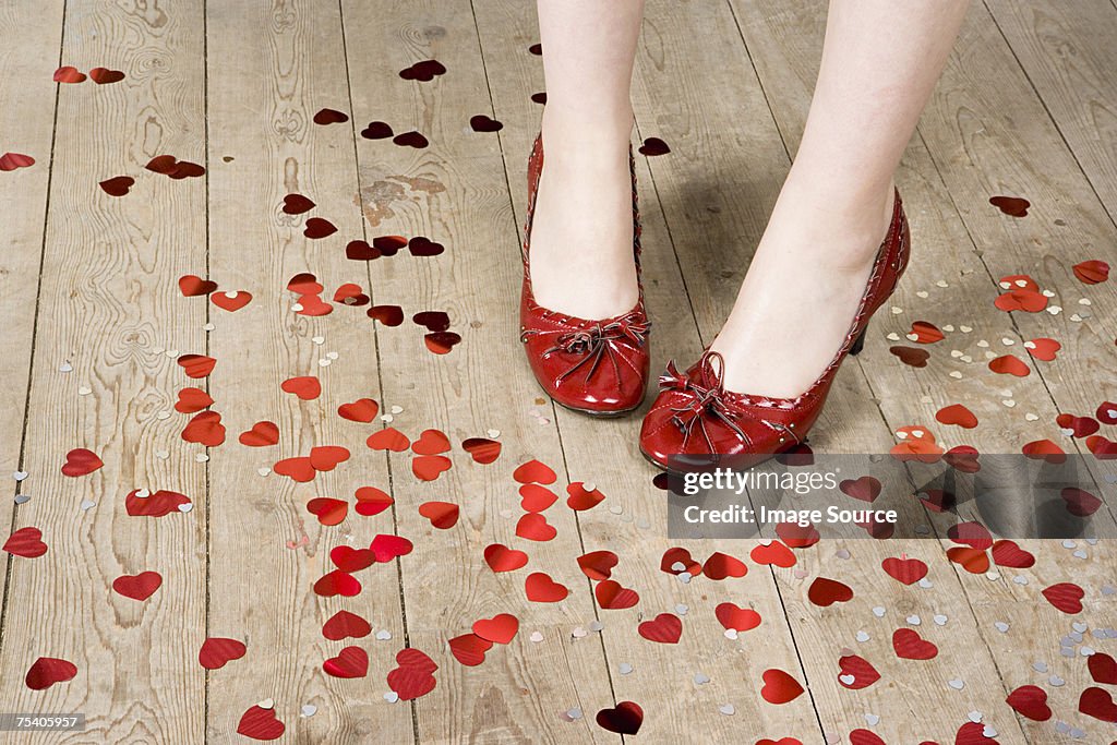 Female feet and heart shaped confetti