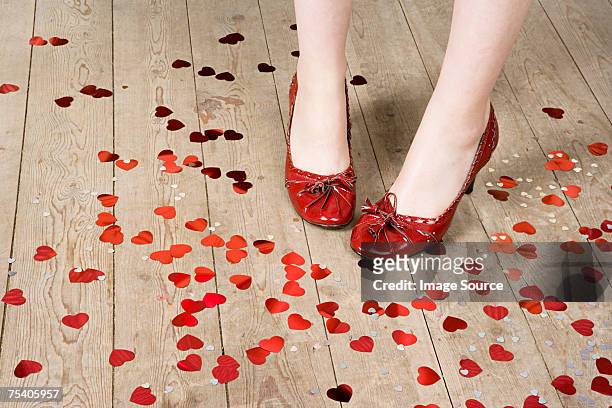 female feet and heart shaped confetti - confetti floor stockfoto's en -beelden