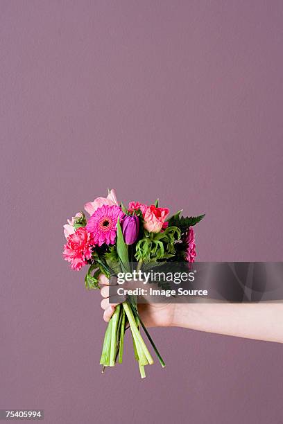 person holding bunch of flowers - bouquet stockfoto's en -beelden