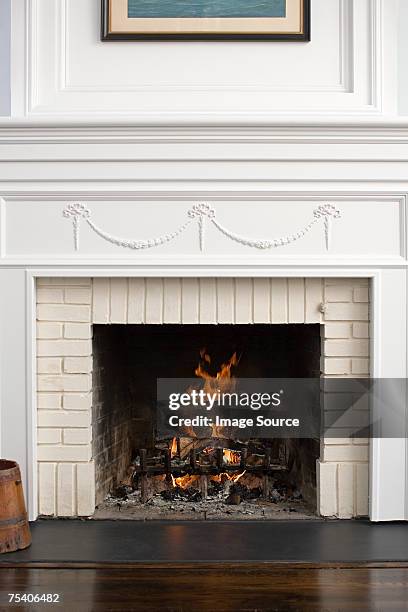 fireplace with fire burning - mantelpiece stock pictures, royalty-free photos & images