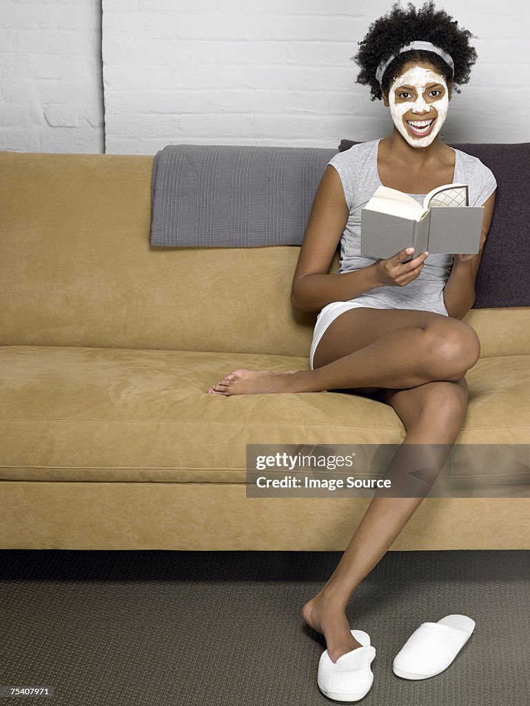 Mujer relajarse con libros y máscara facial