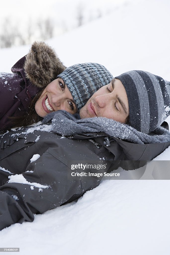 Young couple lying in snow