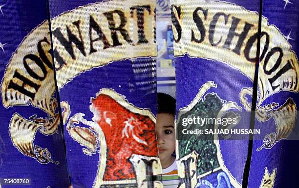 Young Indian child peers through a curtain at a replica of 'Hogwarts School' at a bookshop in Mumbai, 14 July 2007, part of a promotional campaign...