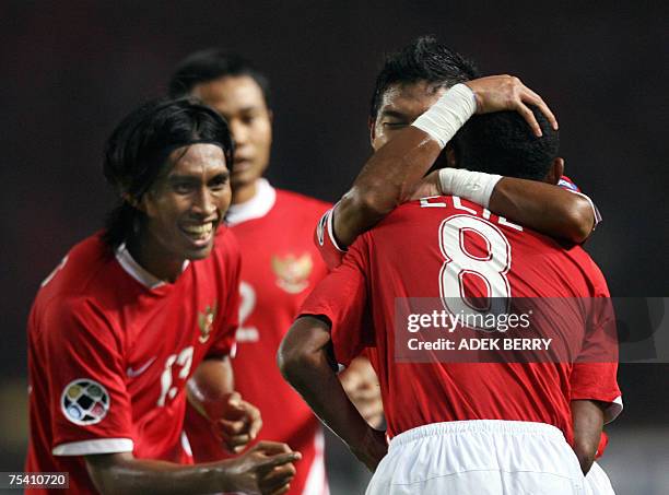 Indonesian player Bambang Pamungkas hugs Elie Aiboy as Budi Sudarsono smiles to celebrate a score for Indonesia during their Asian Cup 2007 Group D...