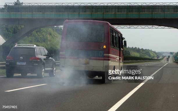 Chinese bus bellows out polluting exhaust smoke on an expressway near the town of Yueyang in Hunan Province, 14 July 2007. Research showing that...