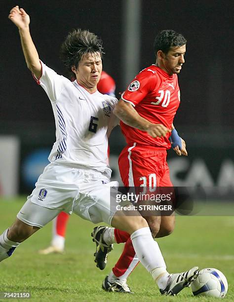 Jakarta, Java, INDONESIA: South Korean Lee Ho vies for the ball with Bahrain's Aal'a Hubail during their Asian Cup 2007 Group D football match at the...