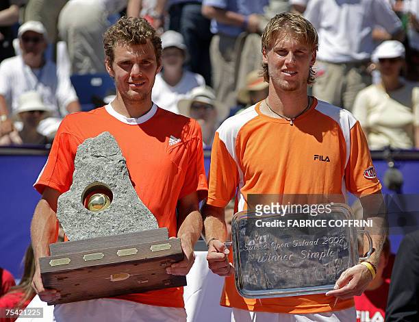 French Paul-Henri Mathieu holds the trophy while posing with Italian Andreas Seppi after he won 6-7 6-4 7-5 during the final tennis match at the...