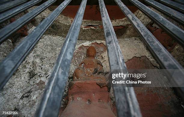 Small Buddhist sculpture is seen below the Leshan Giant Buddha July 13, 2007 in Leshan of Sichuan Province, China. The Giant Buddha, built in 713 AD,...