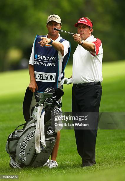 Phil Mickelson of USA lines up a shot with caddy Jim McKay during the final round of The Barclays Scottish Open at Loch Lomond Golf Club on July 15,...