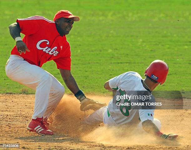 Rio de Janeiro, BRAZIL: Mexico's right fielder Luis Garcia lands safely in second base in front of Cuban short stop Eduardo Paret during the first...