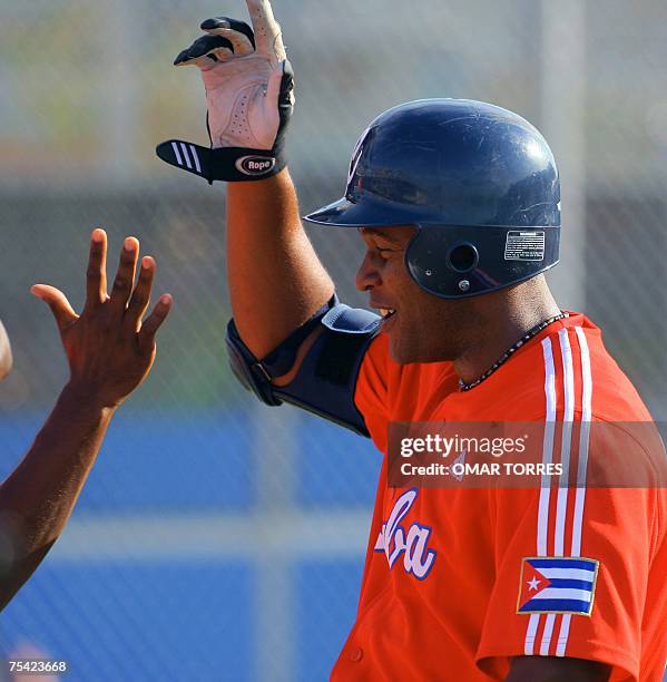 Rio de Janeiro, BRAZIL: Cuban first base Alexander Mayeta celebrates after scoring the fifth run hitting a homerun during the first round of the...