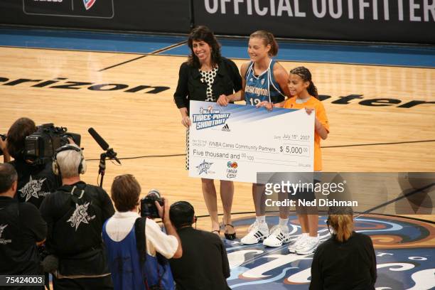 Laurie Koehn of the Washington Mystics is awarded a check by WNBA President Donna Orender following her victory in the 3 Point Shootout prior to the...