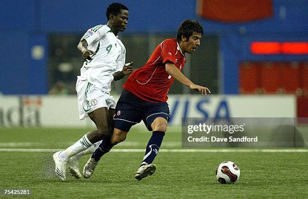 Gary Medel of Team Chile carries the ball as he is defended by Oladapo Olufemi of Team Nigeria during their FIFA U-20 World Cup Canada 2007...