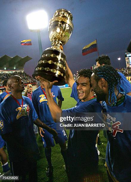 Brazilian midfielder Gilberto Silva , defender Elano and forward Vagner Love, celebrate with the trophy after Brazil won the Copa America...