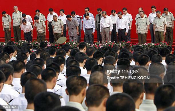 Soldiers of China's People's Liberation Army and communist party members stand in silence during the 80th anniversary celebration of the Chinese...