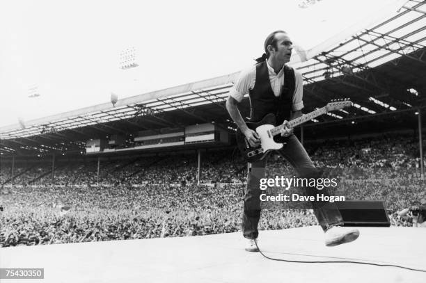 Francis Rossi, singer and guitarist with British rock group Status Quo, in the opening performance at the Live Aid charity concert, Wembley, London,...