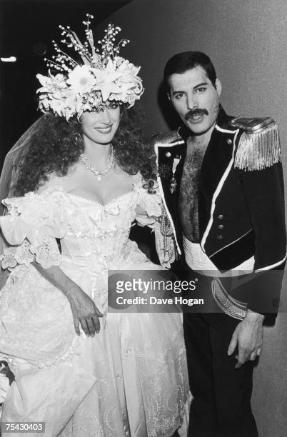 English actress Jane Seymour in a white ballgown with singer Freddie Mercury of British rock group Queen in a military-style dress uniform during the...