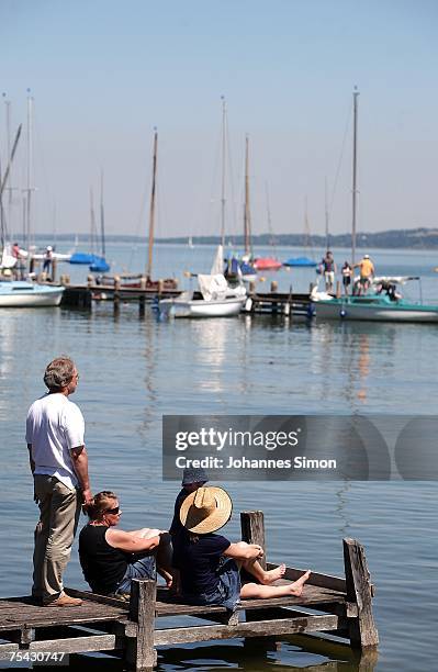 Family enjoys warm weather sitting on a boardwalk at the Ammersee Lake on July 16, 2007 in Diessen am Ammersee, Germany. The heatwave is expected to...