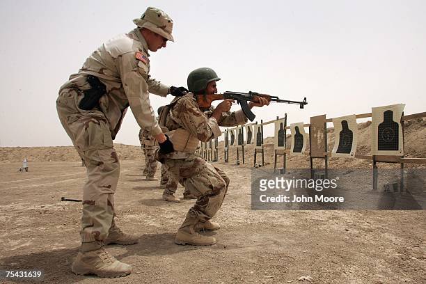 An American Special Forces training supervisor assists Iraqi army soldiers at an advanced combat class July 16, 2007 at a base near Baqouba in the...
