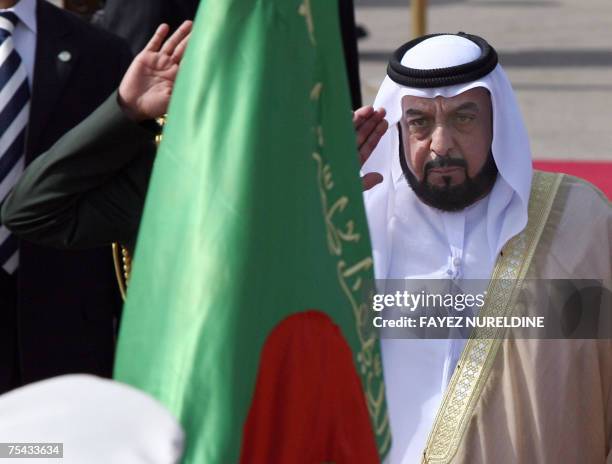 United Arab Emirates President Sheikh Khalifa Bin Zayed Al Nahyan salutes the Algerian flag during a welcoming ceremony at Algiers airport, 16 July...