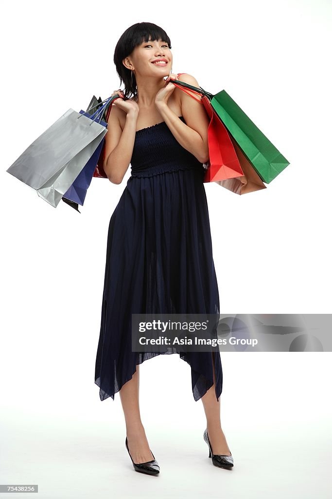 Young woman carrying shopping bags, smiling at camera