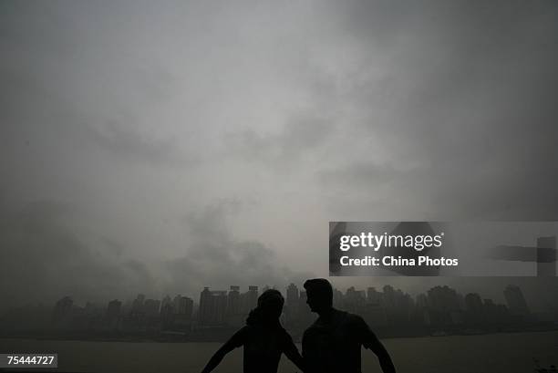 Statue is silhoutted against a cloud shroaded cityscape battered by a rainstorm, which about 8 hours later triggered floods destroying roads and...