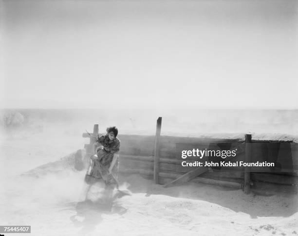 American actress Lillian Gish struggles against the elements in the MGM film 'The Wind', 17th May 1927.