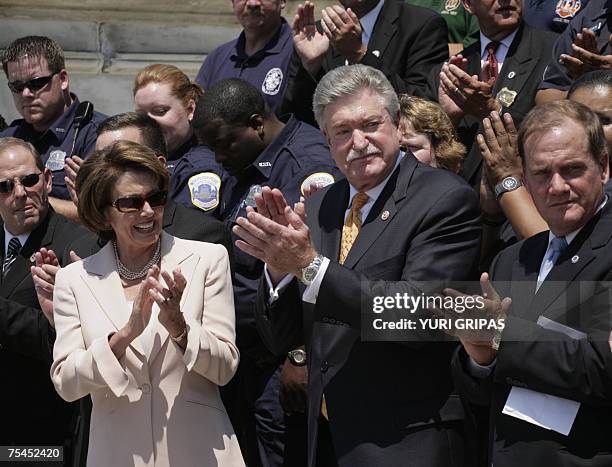 Washington, UNITED STATES: US House Speaker Nancy Pelosi with police and firefighters representatives celebrates passage of legislation extending...