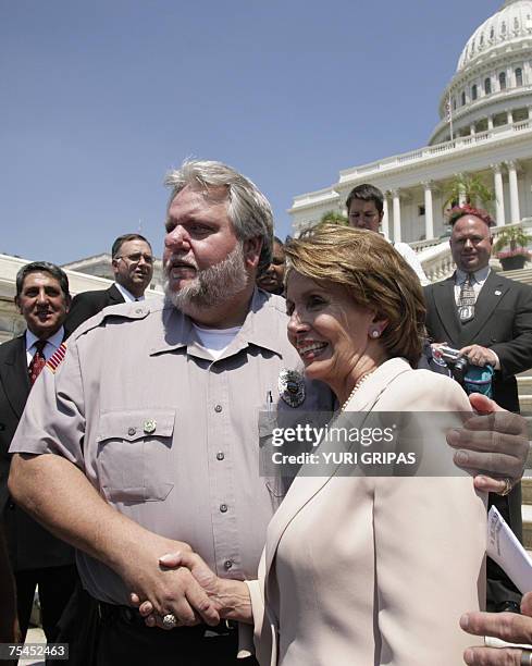 Washington, UNITED STATES: US House Speaker Nancy Pelosi poses for a photo with police and firefighters representatives after a news conference in...