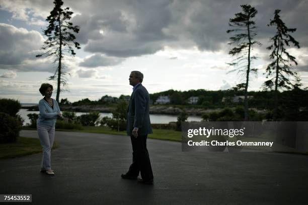 President George W. Bush and First Lady Laura Bush wait outside the main house of the Bush family estate at Walker's Point for the arrival of Russian...