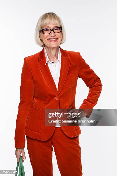 portrait of a smiling scandinavian elderly woman in a red suit. - rood jak stockfoto's en -beelden