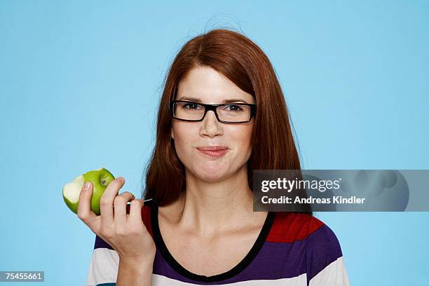 portrait of a young woman eating an apple. - mascar imagens e fotografias de stock