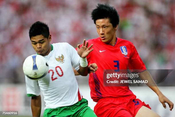Jakarta, Java, INDONESIA: Indonesian Bambang Pamungkas vies for the ball with South Korean Kim Jin-kyu during their Asian Cup 2007 Group D football...