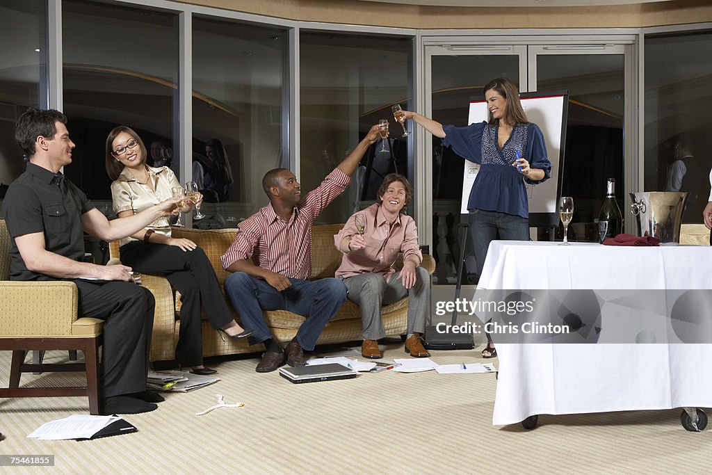 Group of people celebrating in hotel room, having drinks