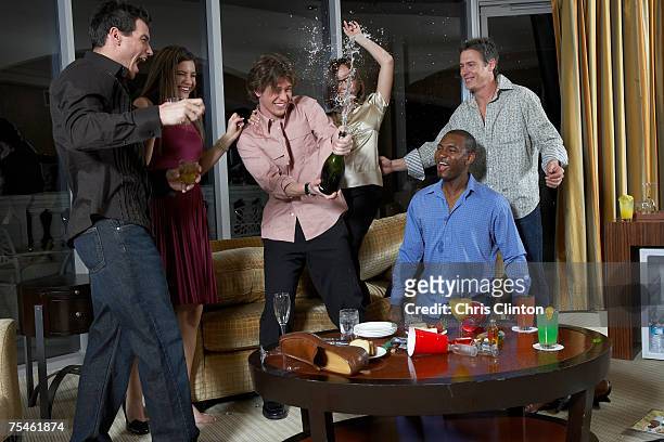 group of people celebrating in hotel room, teenage boy (16-17) spraying champagne - 男性告別單身派對 個照片及圖片檔