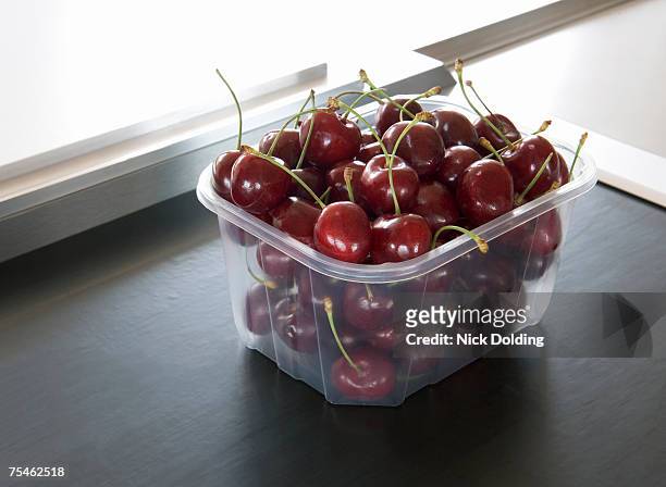 punnet of cherries on supermarket conveyor belt - barquette photos et images de collection