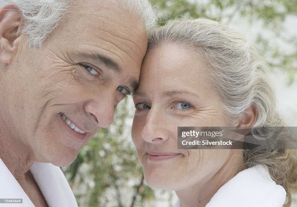 Mature couple in bathrobes, smiling, portrait