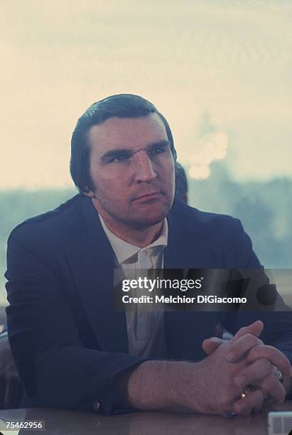 Canadian hockey player and Team Canada General Manager John Ferguson sits at a table and listens with his hands clasped during the Summit Series...