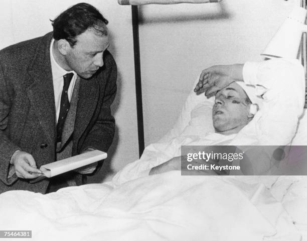 Manchester United footballer Bobby Charlton talking to a journalist while recovering in hospital in Munich after the plane crash which killed 23...