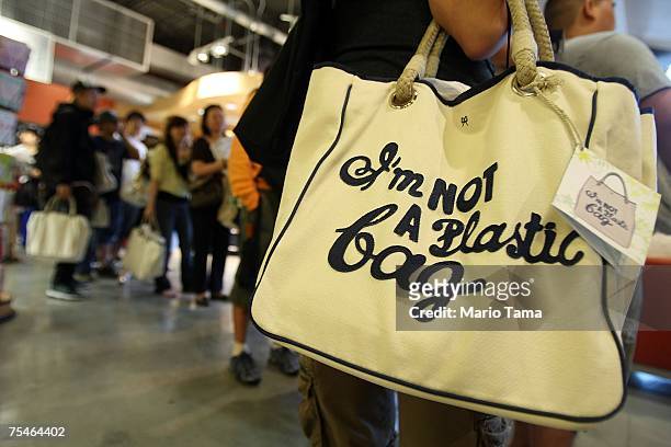Customers stand in line after purchasing the "I'm Not a Plastic Bag" shopping totes by Anya Hindmarch at a Whole Foods Market July 18, 2007 in New...