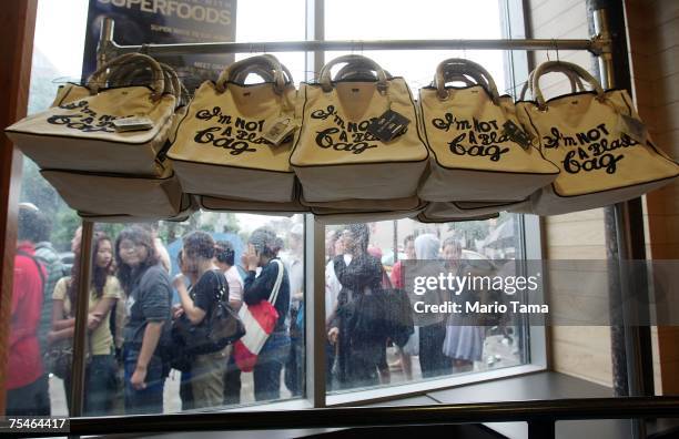 Customers wait in line to purchase the "I'm Not a Plastic Bag" shopping totes by by Anya Hindmarch at a Whole Foods Market July 18, 2007 in New York...