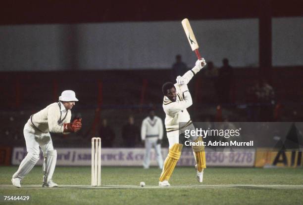 West Indian cricketer Malcolm Marshall plays an unusual shot during a floodlit cricket match between an invitation world XI and Surrey at Crystal...