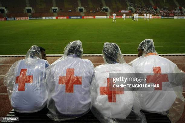 Kuala Lumpur, MALAYSIA: A First aid crew huddle on a sideline bench as the Asian Football Cup Group C match between China and Uzbekistan kicks off at...