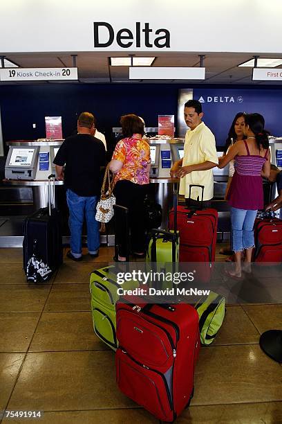 Passengers line up at a ticket counter at Los Angeles International Airport as Delta Air Lines emerges from bankruptcy and turns a profit after...